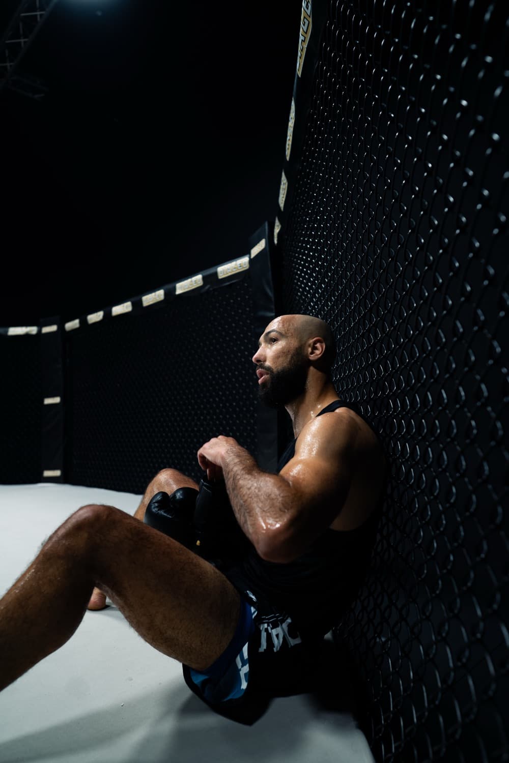 Fighter resting against the cage between rounds